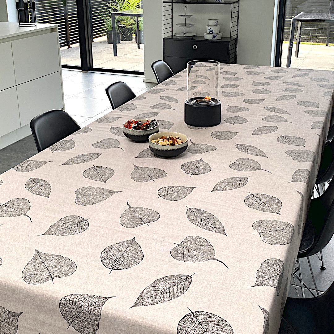 Wachstuch Tischdecke mit detaillierten schwarzen Blättern und Leinenoptik auf dem Tisch