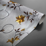 Aufgerollte Altea Metallic Yellow Wachstuch Tischdecke in Silber mit goldenen Blumen