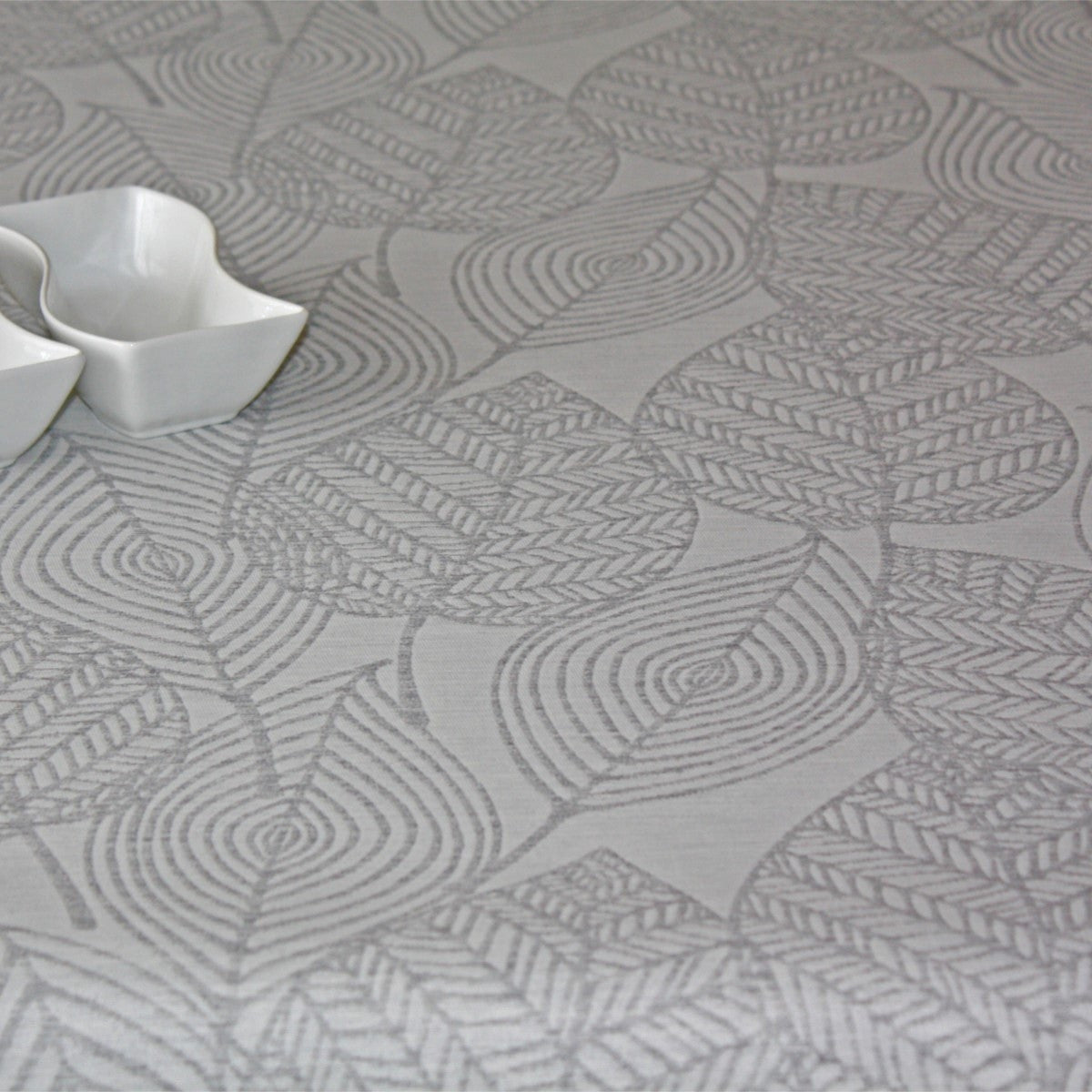Amberes Jacquard, graue Blätter. Jacquardgewebte abwaschbare Tischdecke mit grauen Blattkonturen auf naturfarbenem Grund