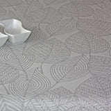 Amberes Jacquard, graue Blätter. Jacquardgewebte abwaschbare Tischdecke mit grauen Blattkonturen auf naturfarbenem Grund
