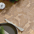 Nahaufnahme der Weihnachtstischdecke Golden Reindeers mit goldenen Rentieren auf sandfarbenem Grund