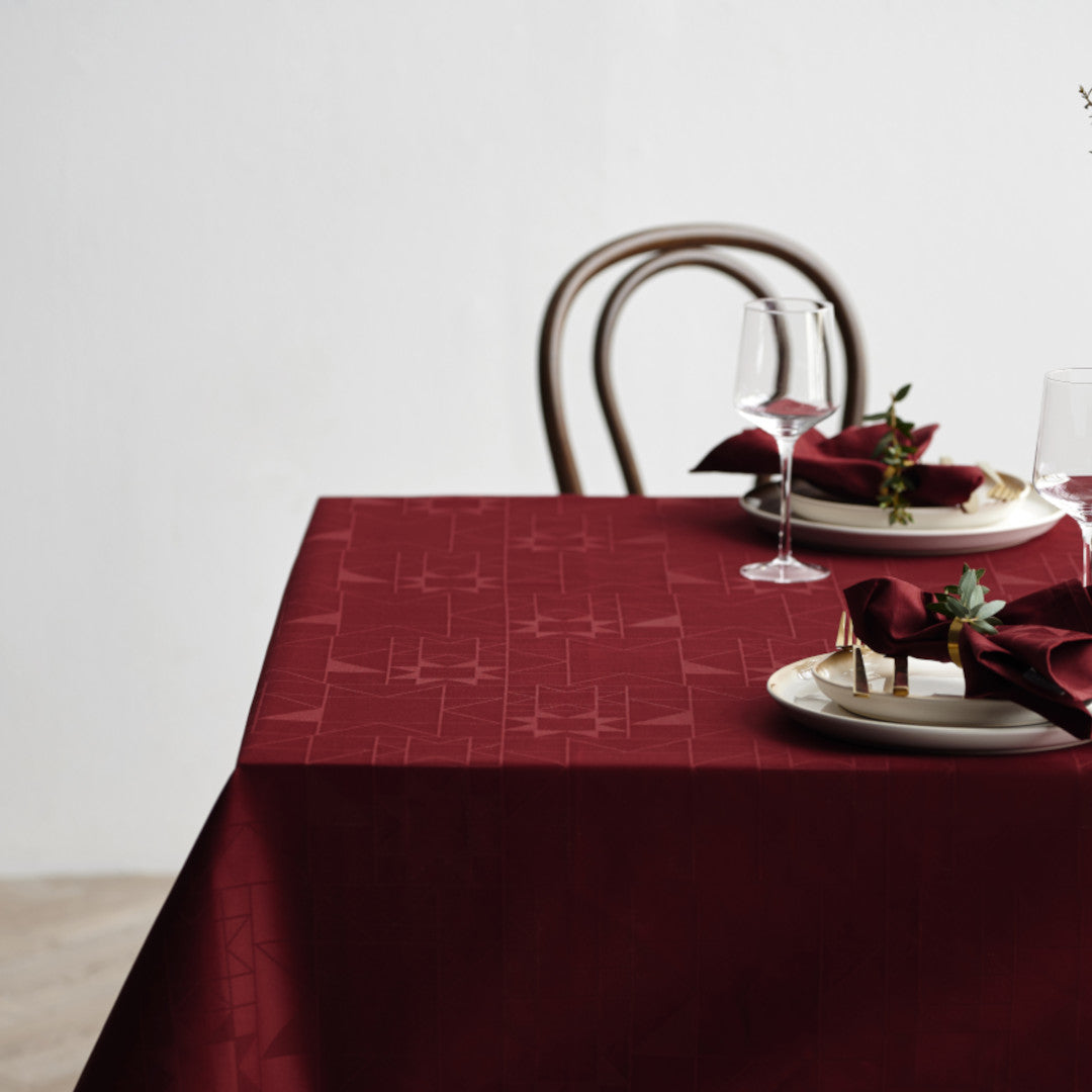 Ambienteaufnahme der Södahl Star Damask Weihnachtstischdecke Rot mit Weihnachtsdekorationen und Gedeck 140x270